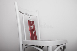 带红色礼物和银色天使丝带的白色椅子