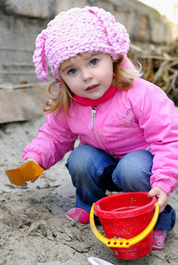 穿粉红色衣服的小女孩玩沙子