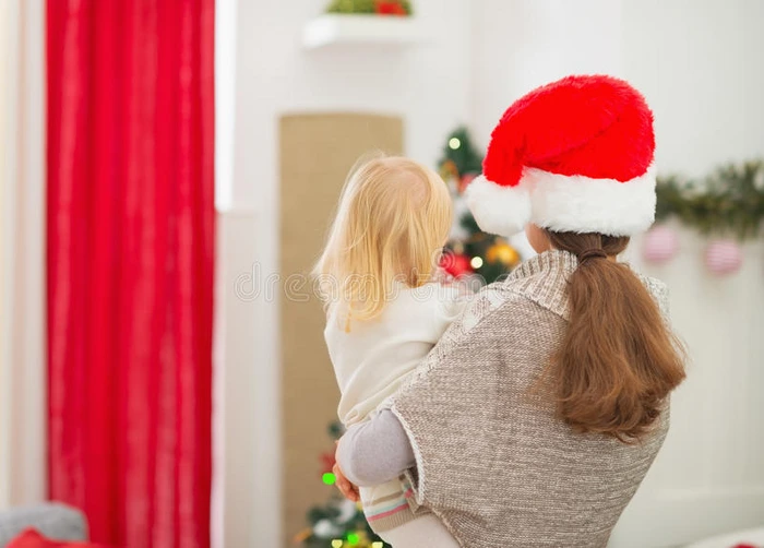 妈妈抱着孩子看着圣诞树