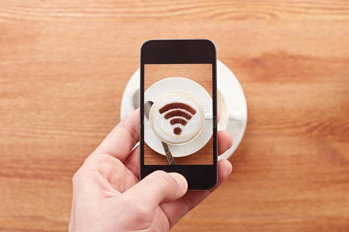 智能手机在拿铁咖啡上拍摄免费wifi标志