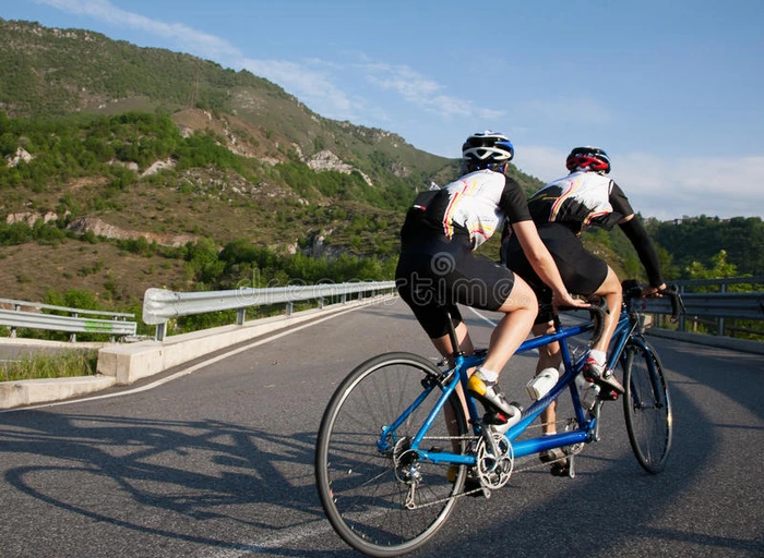骑双人自行车的人在山路上坡