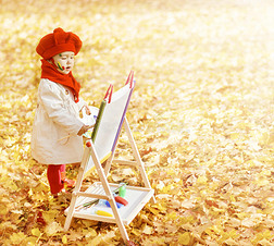 儿童在秋季公园画架上画画。有创造力的孩子