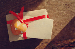 石头的心，空荡荡的照片，躺在一个红色蝴蝶结的礼物包装上