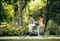 骑双人自行车的年轻夫妇