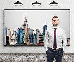 一位穿着正式衣服的英俊男子站在墙上的纽约市照片前面。