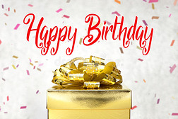 特写金色礼品盒，生日快乐字样和五彩纸屑模糊背景