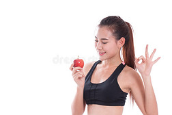 健身妇女拿着苹果并显示OK标志。