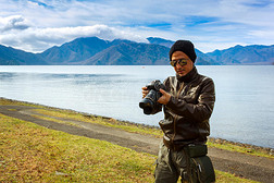 亚洲男人正在湖边拍照