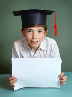 男孩戴着毕业帽，手里拿着白纸