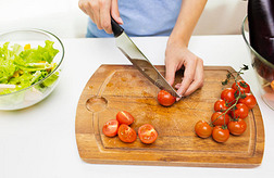女人用刀子切西红柿的特写