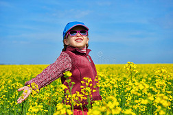 女孩在油菜籽地里开着鲜艳的黄花，春天的风景