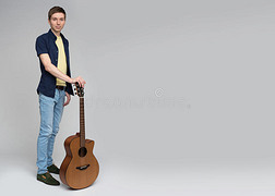 自信的年轻人拿着吉他站着