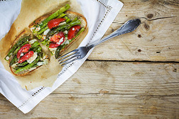 绿色芦笋，西红柿和帕尔马干酪免费烤面包在乡村木桌上，从上面看，复制空间