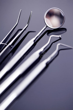 牙科镜和其他工具在蓝色闪亮的背景