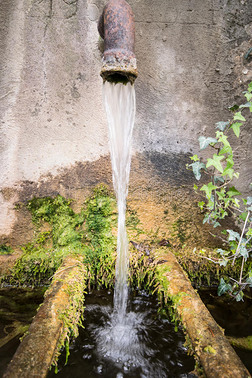 一滴水落到一根古老的圆形苔藓石桶里。