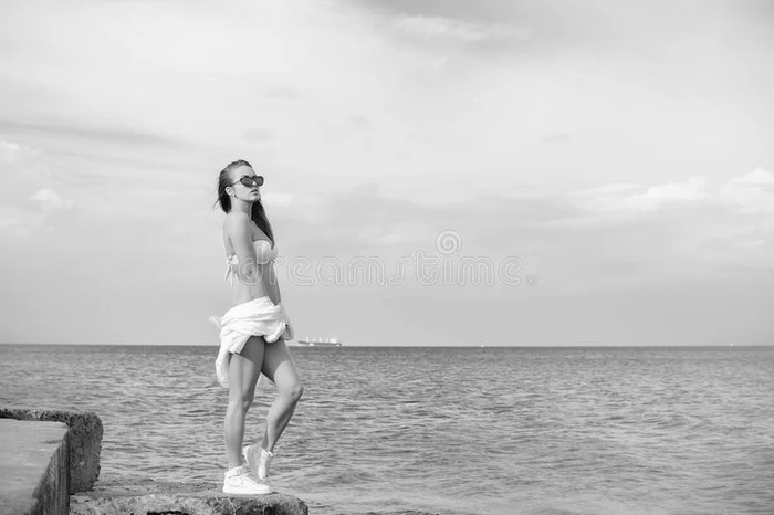 黑白摄影美丽的年轻女士享受海景在户外水天背景 肖像