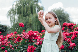 盛开的花园里美丽的小女孩做了一个手势