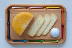 一块美味的奶酪在切割板上用刀和高尔夫球座