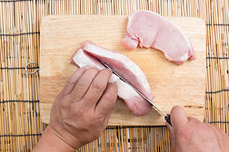 厨师在木板上切生猪肉