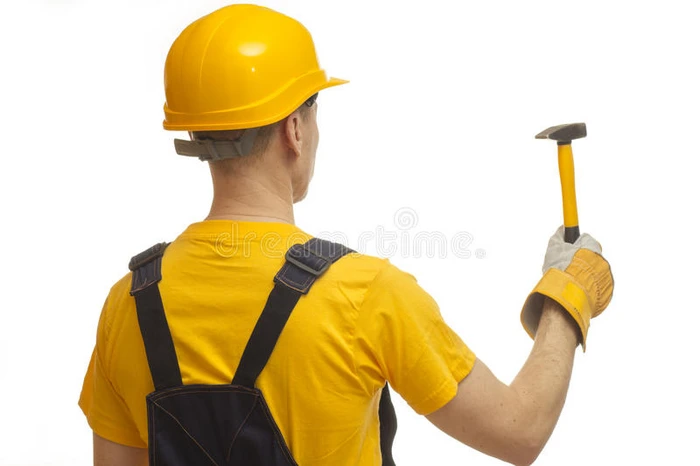 用锤子穿黄色头盔的建设者