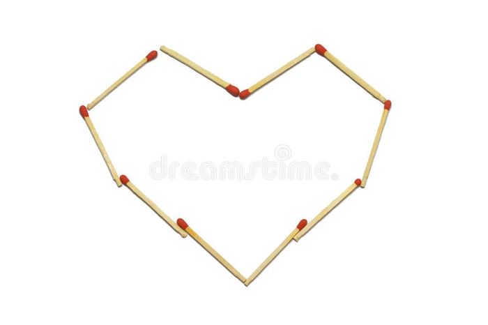 关闭一组红色火柴棒排列在白色背景上隔离的心脏图案中