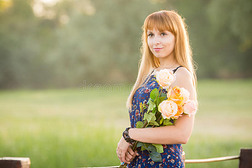 美丽的女孩站在河桥上手里拿着一束花 肖像
