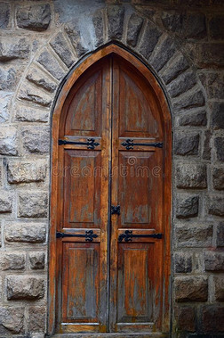 完全的一级防范禁闭-古代的木制的关闭着的门和多石头的墙