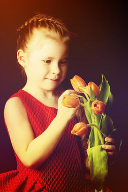小的女孩和一花束关于郁金香向一bl一ckb一ckground.