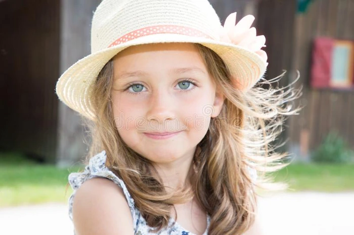 美好漂亮的小孩女孩和深的蓝色眼睛采用和煦的照到阳光的公园
