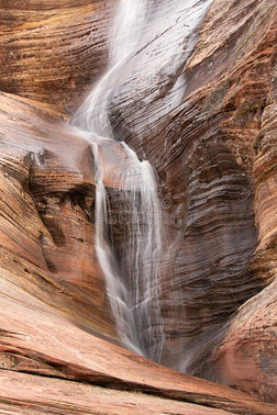 一临时的瀑布越过红色的砂岩悬崖人为的在旁边雨采用