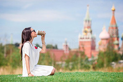 幸福的年幼的都市的女人喝饮料咖啡豆采用欧洲的城市.