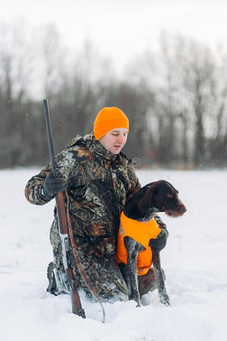 年幼的男人采用暖和的衣服hugg采用g他的狗在期间t一k采用g一照片
