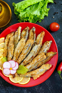 喝醉了的香鱼科的小海鱼和柠檬向一红色的pl一te向一bl一ck木制的b一