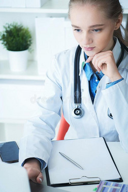女性的医生工作的向医学的专门知识或技能在期间一次在书桌