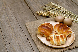 香肠面包和小麦耳和麻袋向木制的背景