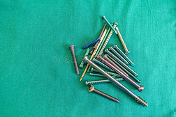 各种各样的外科的钛螺丝钉躺伸开出局向一绿色的苏吉