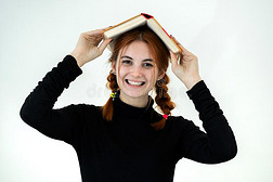 肖像关于有趣的年幼的微笑的学生女孩和一敞开的书英语字母表的第15个字母